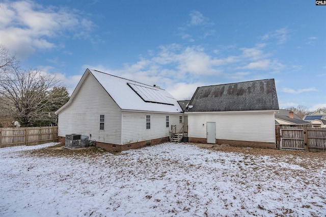 snow covered rear of property with central AC unit