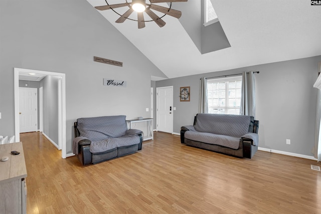 living room featuring high vaulted ceiling, light hardwood / wood-style floors, and ceiling fan