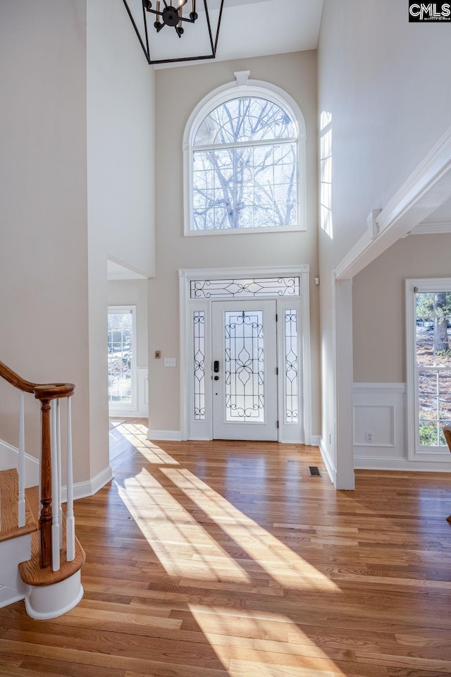 foyer featuring an inviting chandelier, hardwood / wood-style floors, and a high ceiling