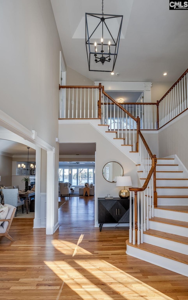 foyer entrance featuring hardwood / wood-style flooring, a high ceiling, and a notable chandelier