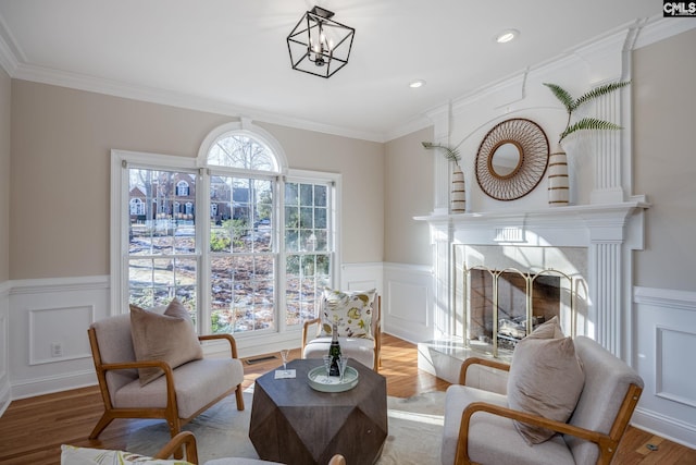 living area with crown molding and light hardwood / wood-style flooring