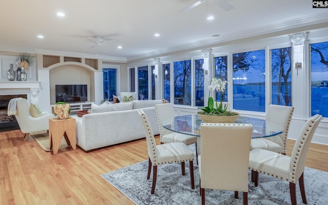 dining area featuring light hardwood / wood-style flooring, ornamental molding, and ceiling fan