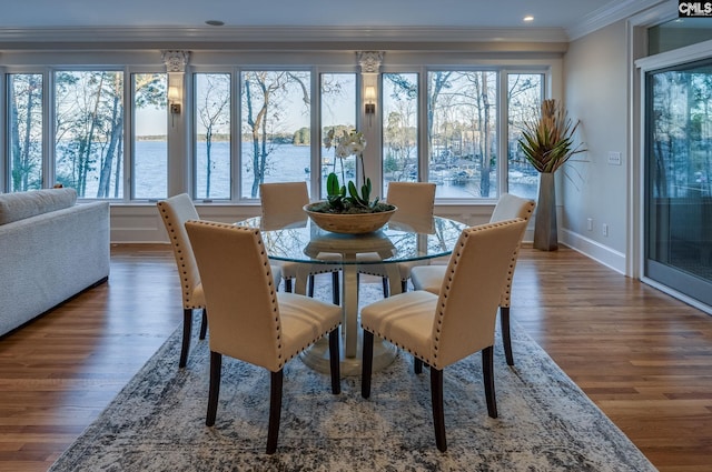 dining room with a water view, dark hardwood / wood-style floors, and crown molding