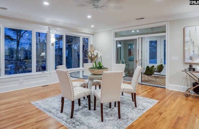 dining space with light hardwood / wood-style flooring, ornamental molding, and ceiling fan