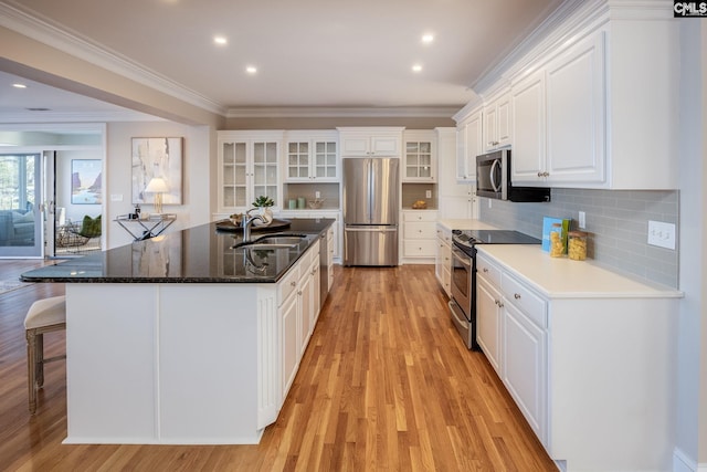 kitchen featuring appliances with stainless steel finishes, white cabinetry, sink, decorative backsplash, and crown molding