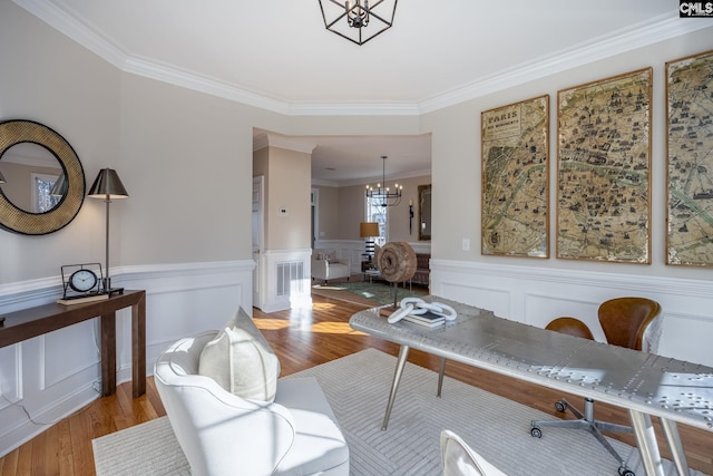 interior space with light hardwood / wood-style flooring, ornamental molding, and a chandelier