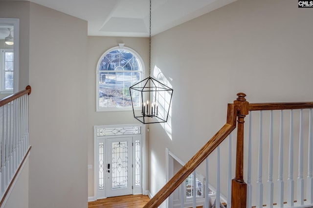 foyer featuring a notable chandelier, a wealth of natural light, and wood-type flooring