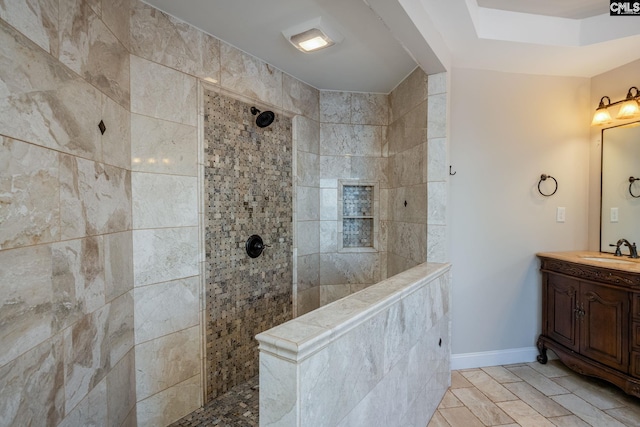 bathroom with tiled shower, vanity, and tile patterned flooring