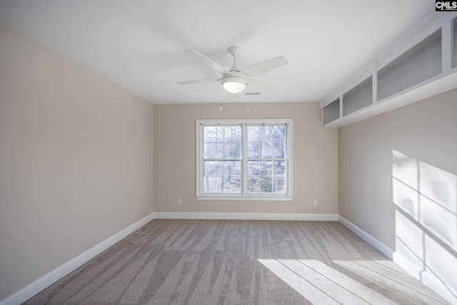 carpeted spare room featuring ceiling fan