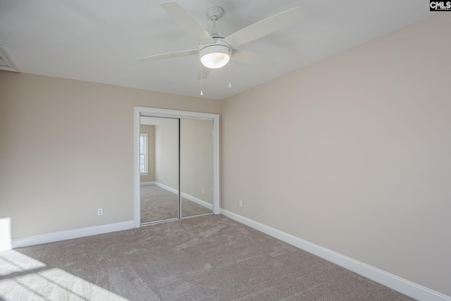 unfurnished bedroom with ceiling fan, light carpet, and a closet