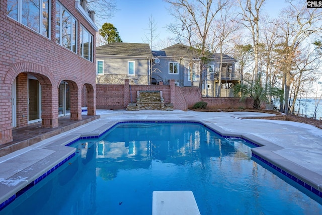 view of swimming pool with a diving board and a patio area