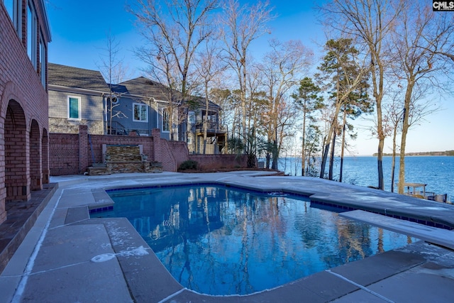 view of pool with a patio, a water view, and a diving board