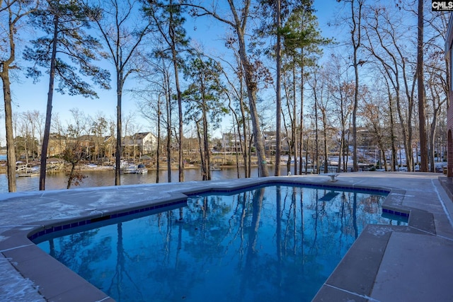 view of pool featuring a water view and a patio area