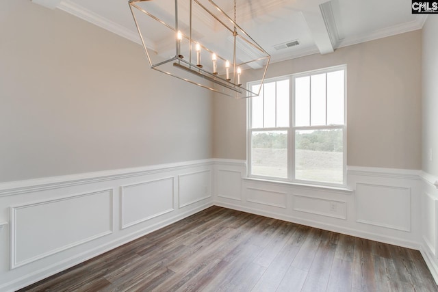 spare room featuring crown molding, hardwood / wood-style floors, and a chandelier