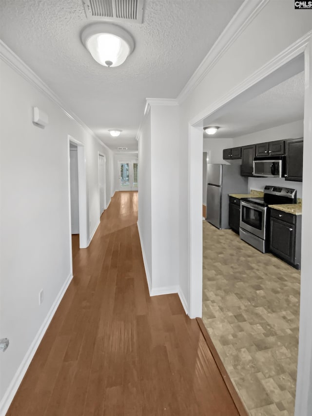 hallway with crown molding, a textured ceiling, and light hardwood / wood-style floors