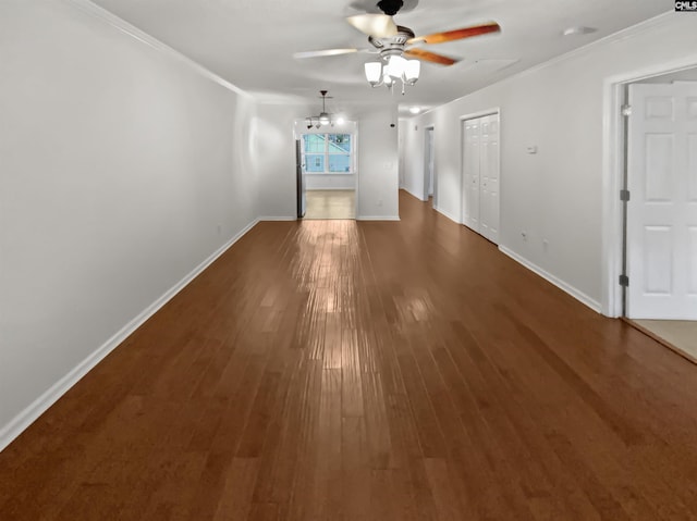 spare room featuring dark wood-type flooring, ornamental molding, and ceiling fan