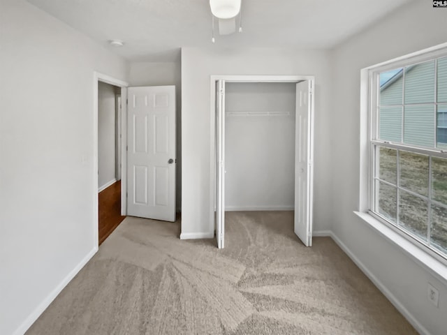 unfurnished bedroom featuring light carpet and a closet