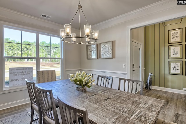 dining room featuring crown molding, dark hardwood / wood-style floors, and a chandelier