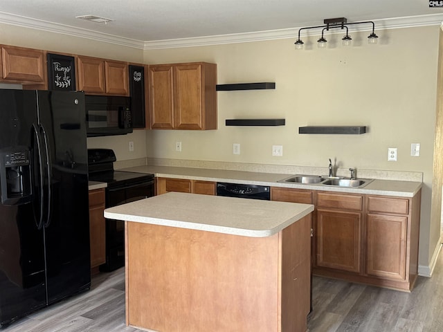 kitchen featuring a kitchen island, sink, light wood-type flooring, and black appliances