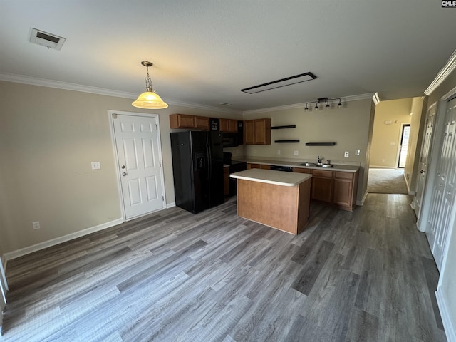 kitchen with pendant lighting, sink, dark wood-type flooring, black appliances, and a kitchen island