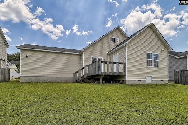 back of property featuring a wooden deck and a lawn