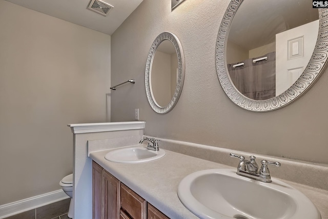 bathroom with tile patterned floors, toilet, and vanity