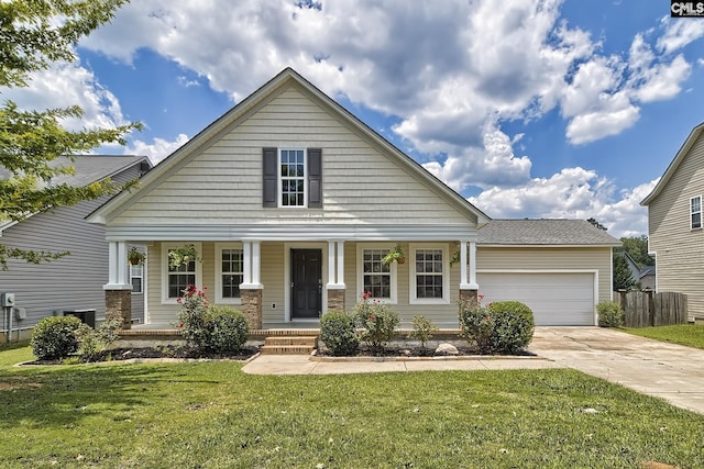 view of front of home featuring a garage, a front yard, and a porch