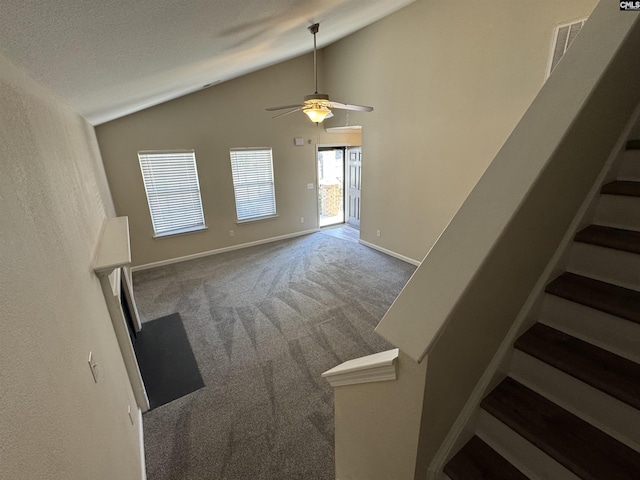 unfurnished living room featuring ceiling fan, lofted ceiling, and carpet floors