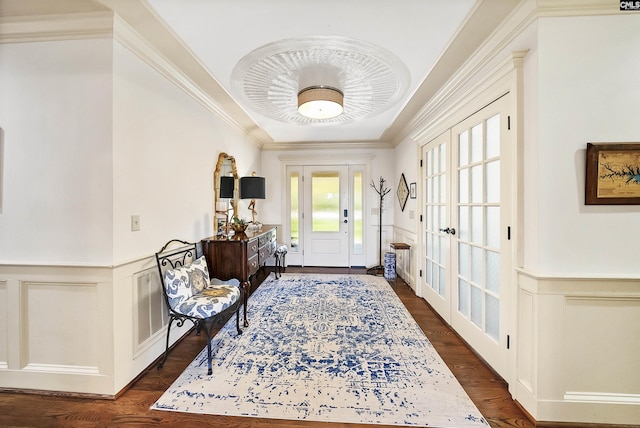 foyer featuring french doors, ornamental molding, and dark hardwood / wood-style flooring