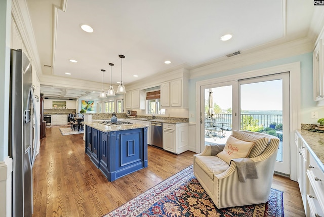 kitchen featuring blue cabinetry, stainless steel appliances, light hardwood / wood-style floors, and a kitchen island