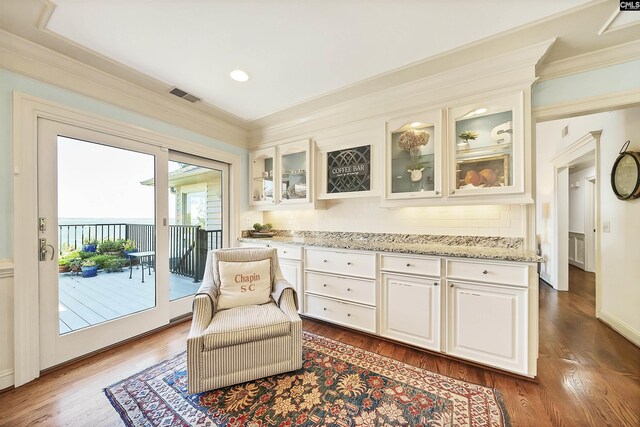 living area featuring crown molding and dark wood-type flooring