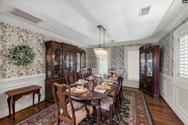 dining space with ornamental molding and dark hardwood / wood-style floors