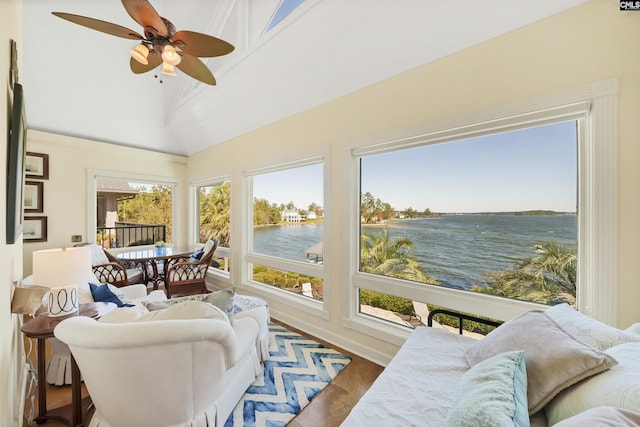 sunroom featuring a water view, vaulted ceiling with beams, and ceiling fan