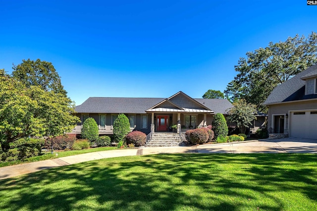 view of front of property with a garage, covered porch, and a front lawn