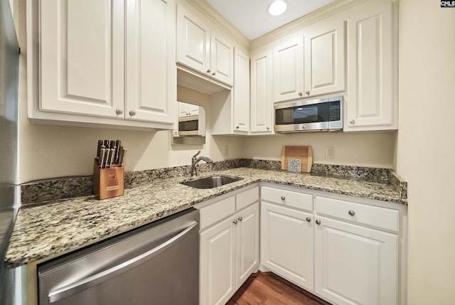 kitchen featuring white cabinetry, appliances with stainless steel finishes, sink, and light stone counters