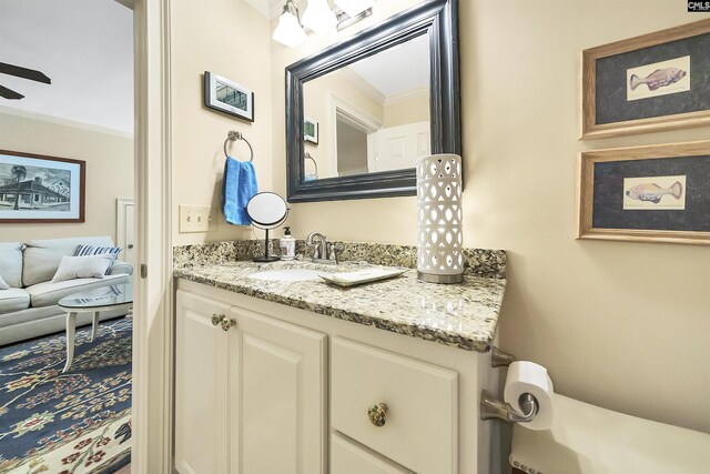 bathroom featuring ceiling fan, ornamental molding, and vanity