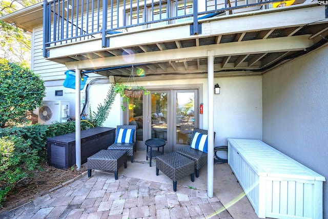 view of patio featuring ac unit, a fireplace, french doors, and a balcony