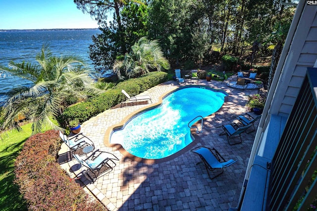 view of pool with a water view and a patio area