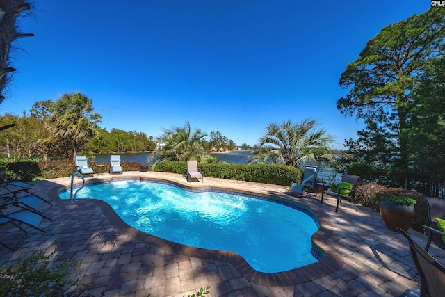 view of swimming pool with a water view and a patio