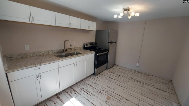 kitchen featuring white cabinetry, sink, light stone counters, and stainless steel appliances