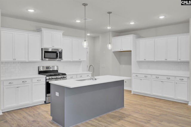 kitchen featuring stainless steel appliances, sink, and white cabinets