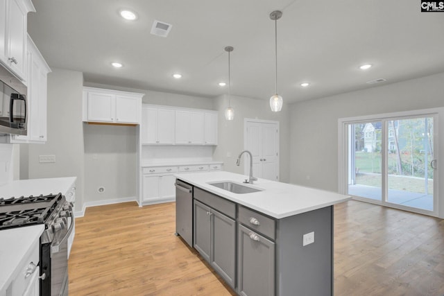 kitchen featuring a kitchen island with sink, gray cabinetry, and white cabinets