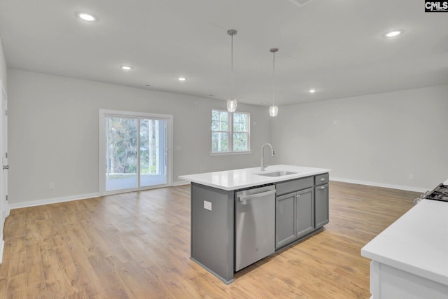 kitchen featuring gray cabinets, an island with sink, sink, hanging light fixtures, and stainless steel appliances