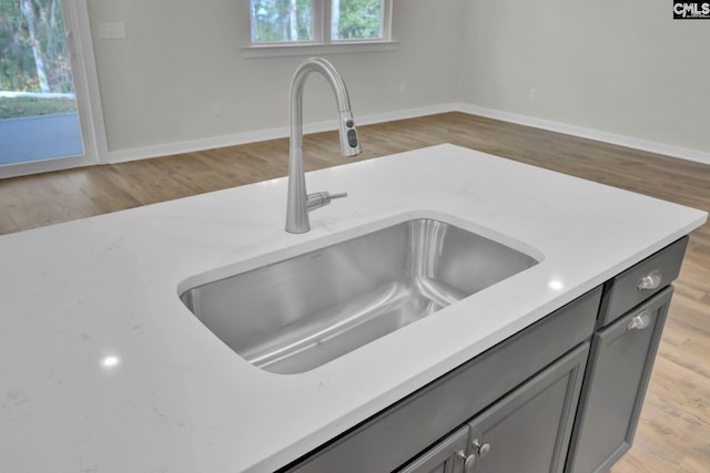 details featuring sink, gray cabinets, and light wood-type flooring