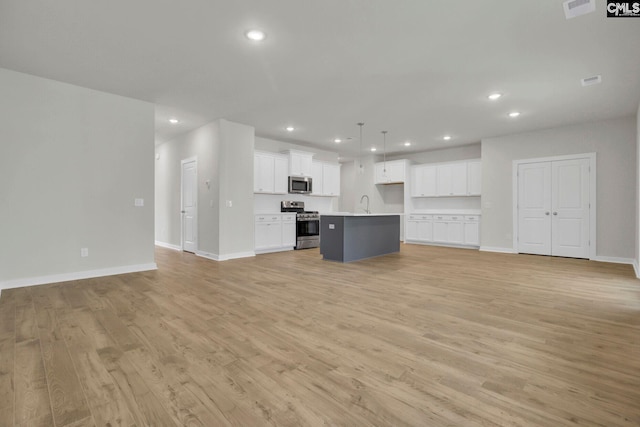 unfurnished living room with sink and light hardwood / wood-style floors