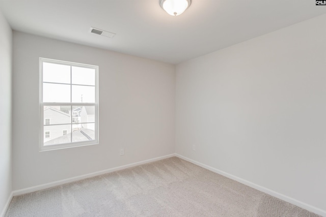 spare room featuring light carpet