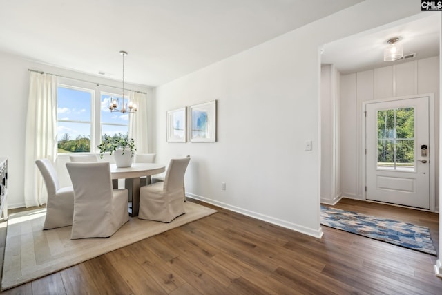 dining space featuring an inviting chandelier and hardwood / wood-style flooring