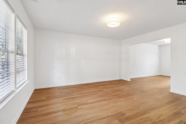 spare room with light hardwood / wood-style floors and a textured ceiling