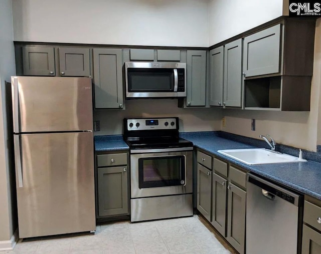 kitchen with stainless steel appliances, gray cabinets, and sink