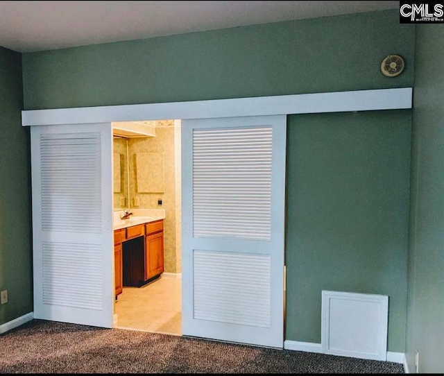 interior space with light colored carpet and ensuite bathroom